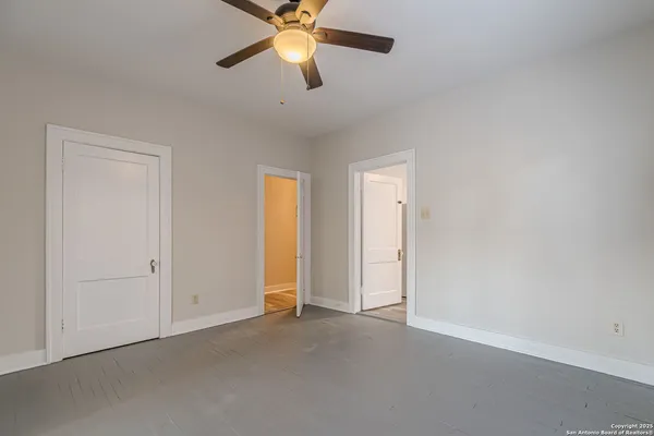 an empty room with closet and a chandelier fan