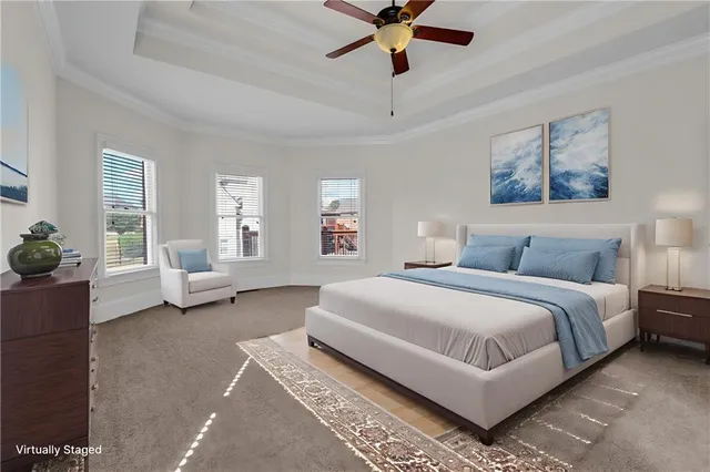 a spacious bedroom with a bed a couch and a chandelier