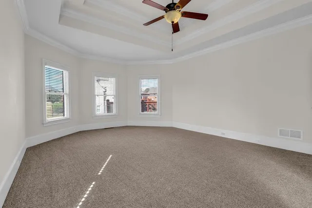 en empty room with windows and ceiling fan view