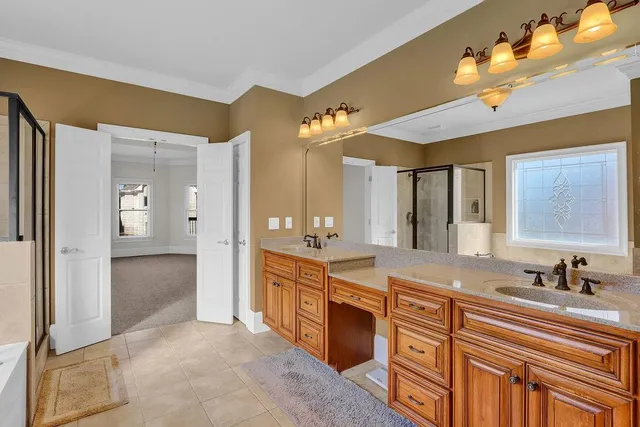 a spacious bathroom with a shower a sink and a mirror