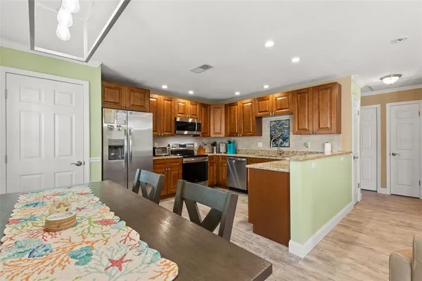 a kitchen with a refrigerator a sink dishwasher with a dining table and chairs