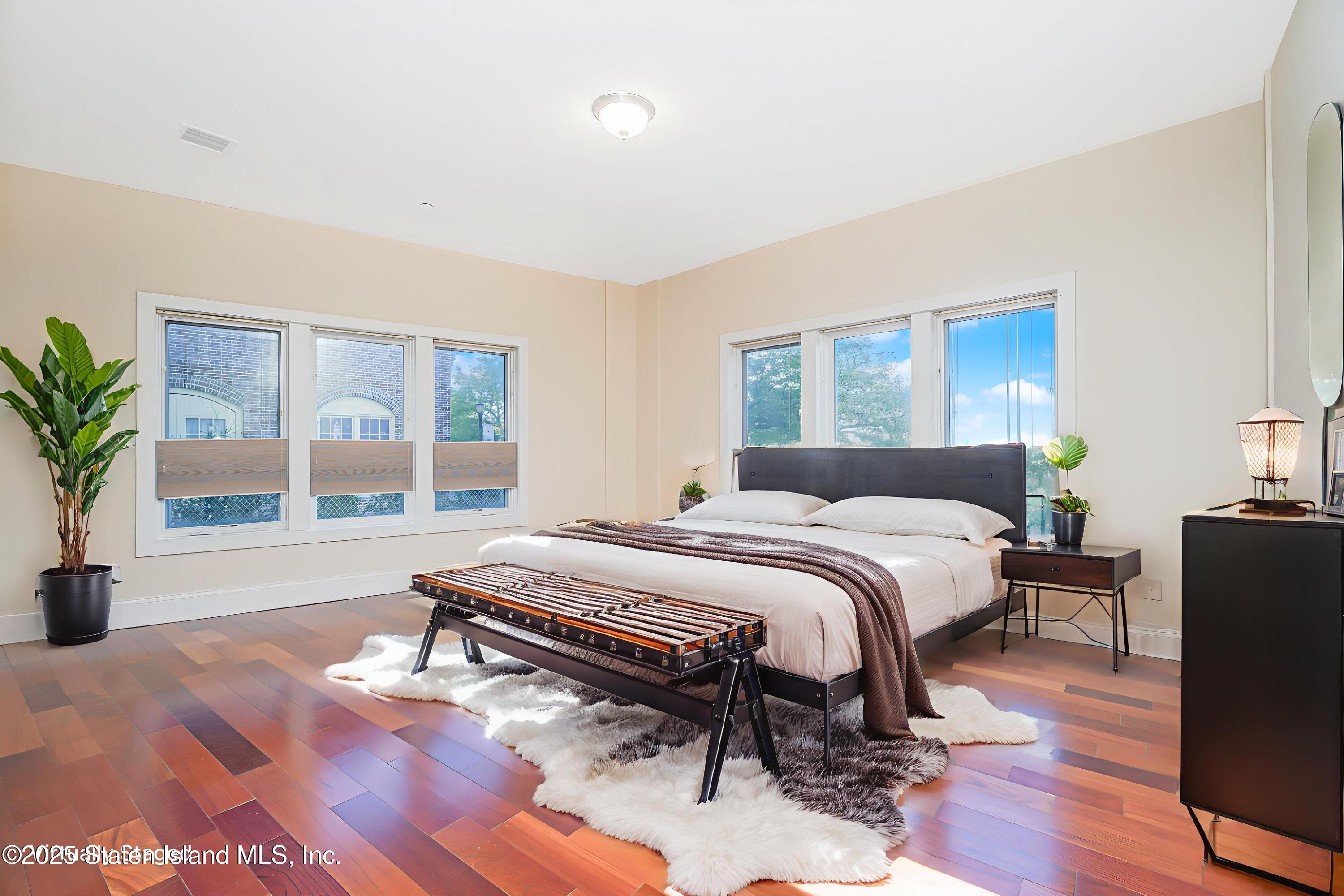 90 Bay Street Landing, Unit 1E Staten Island, NY 10301 - Photo 17 of 43 a bedroom with a large bed and a large window