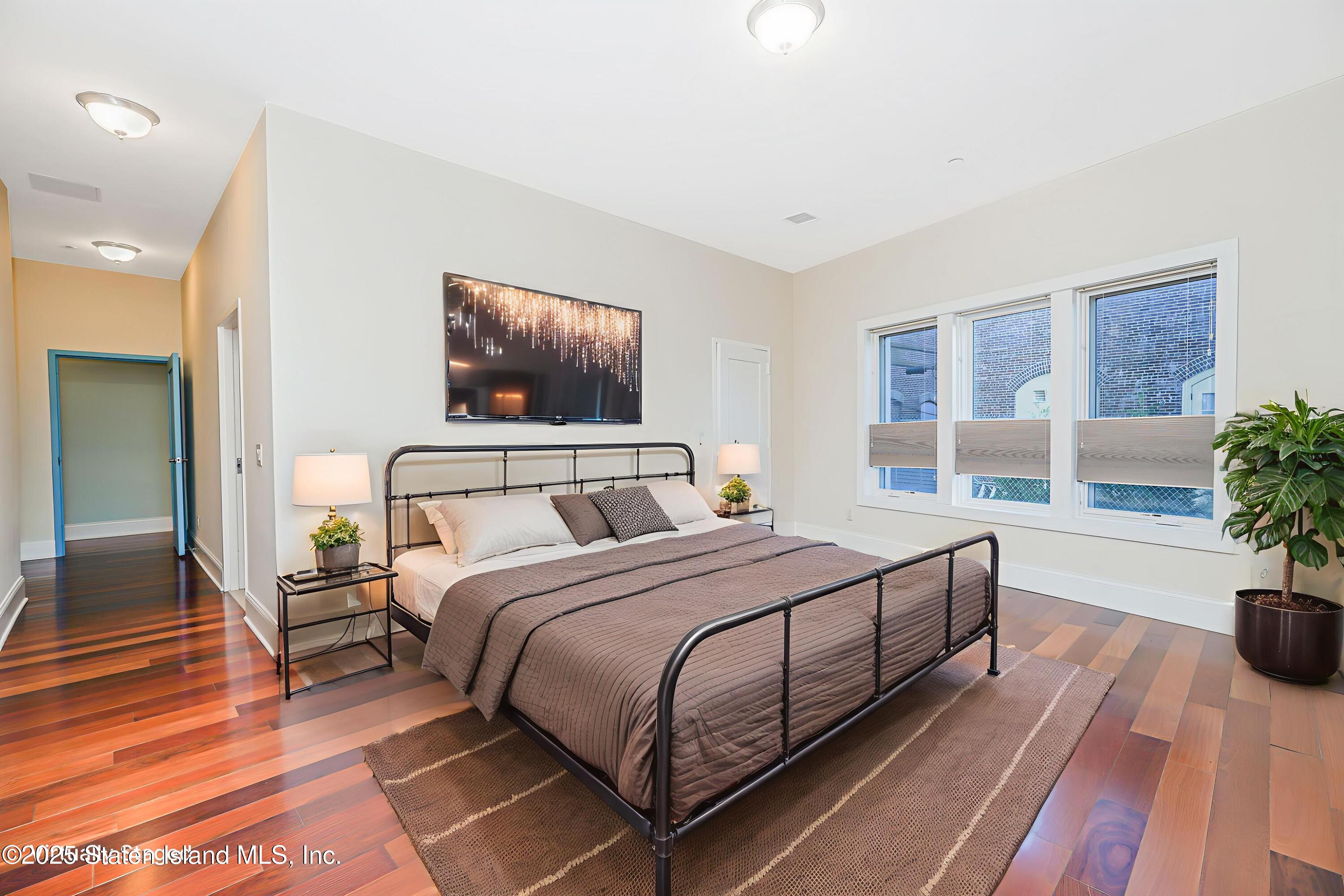 90 Bay Street Landing, Unit 1E Staten Island, NY 10301 - Photo 19 of 43 a bedroom with double bed and a potted plant