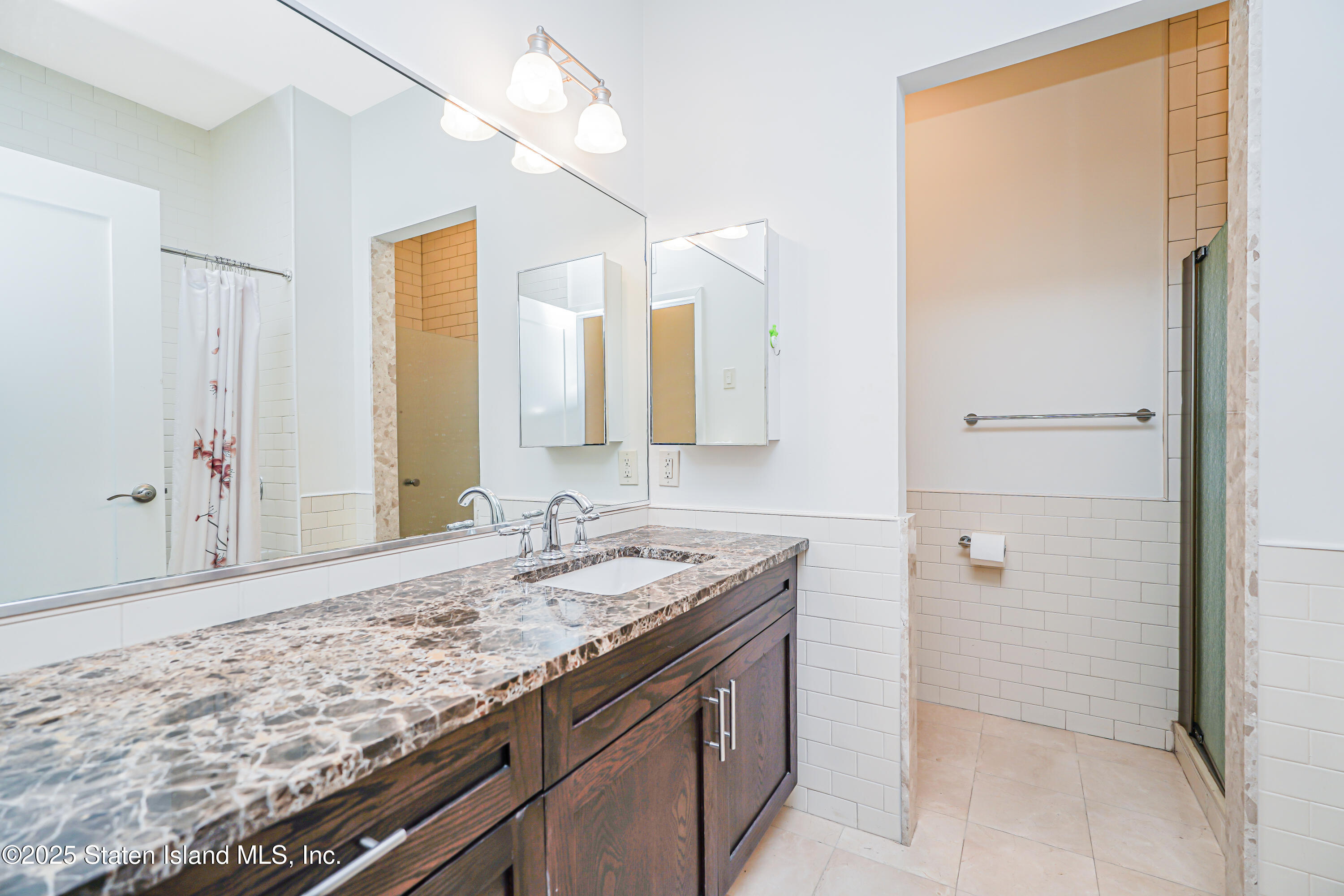 90 Bay Street Landing, Unit 1E Staten Island, NY 10301 - Photo 23 of 43 a bathroom with a granite countertop sink and a mirror