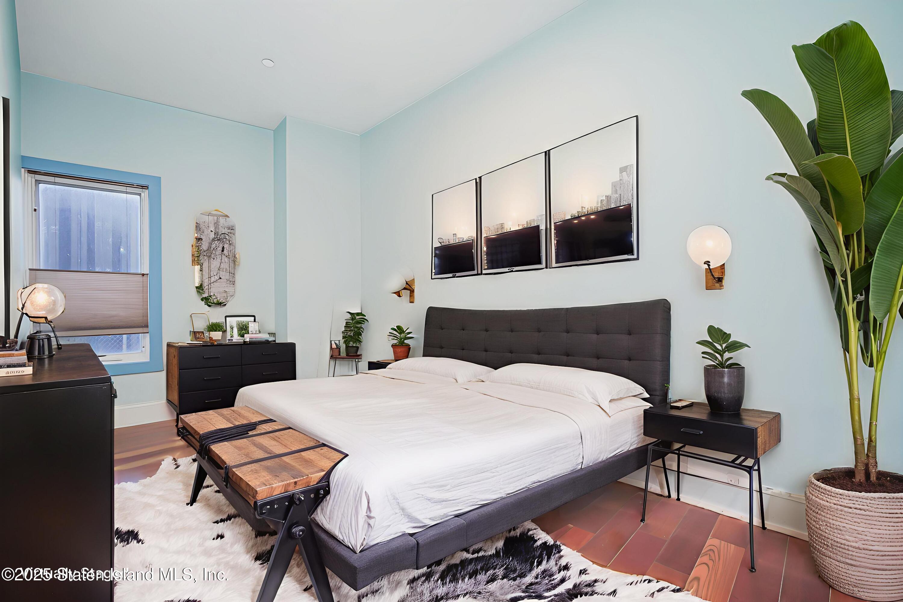 90 Bay Street Landing, Unit 1E Staten Island, NY 10301 - Photo 27 of 43 a bedroom with a bed table and a potted plant