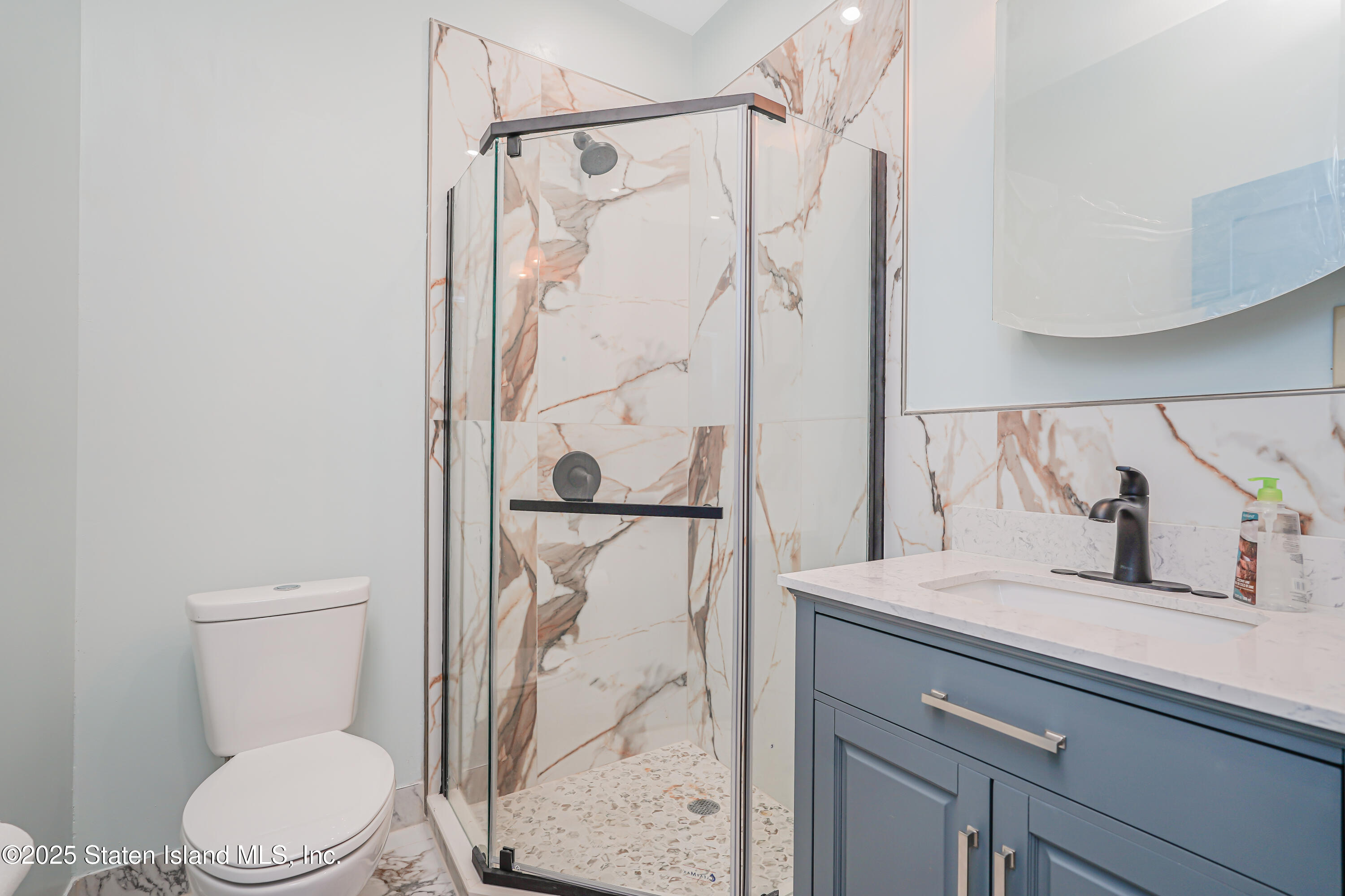 90 Bay Street Landing, Unit 1E Staten Island, NY 10301 - Photo 30 of 43 a bathroom with a granite countertop sink toilet and shower