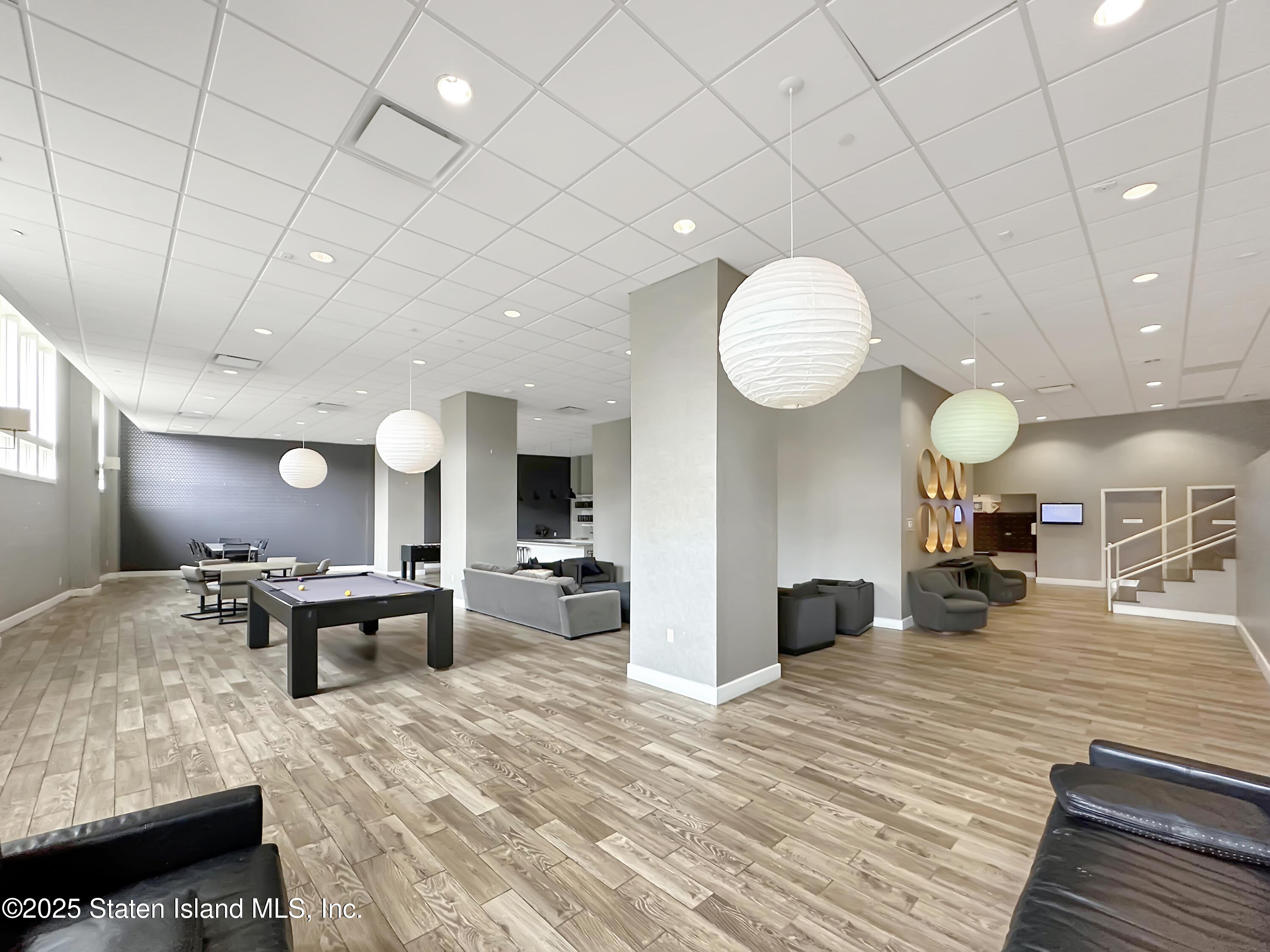 90 Bay Street Landing, Unit 1E Staten Island, NY 10301 - Photo 33 of 43 a large room with kitchen island a dining table and a fireplace