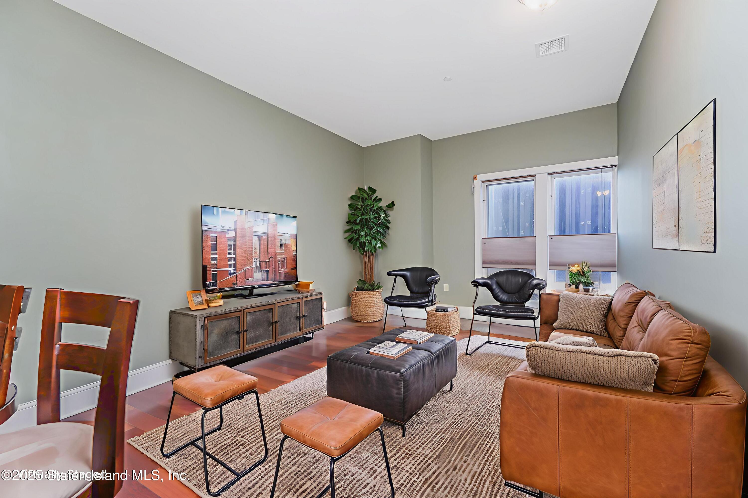 90 Bay Street Landing, Unit 1E Staten Island, NY 10301 - Photo 5 of 43 a living room with furniture a flat screen tv and a window
