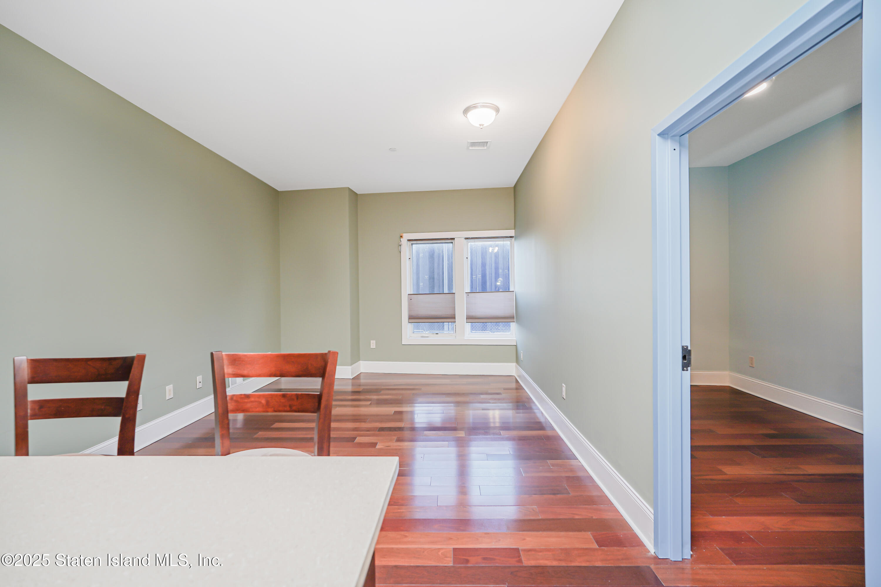 90 Bay Street Landing, Unit 1E Staten Island, NY 10301 - Photo 6 of 43 a hallway with a wooden floor and next to a large window