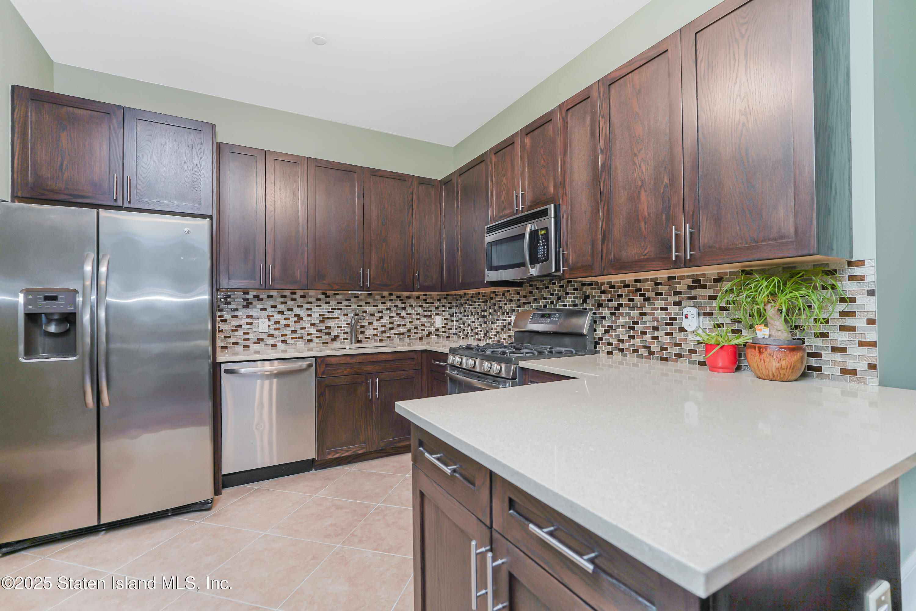 90 Bay Street Landing, Unit 1E Staten Island, NY 10301 - Photo 10 of 43 a kitchen with a sink a microwave and cabinets
