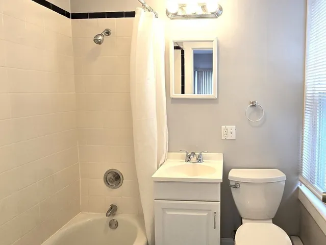 a bathroom with a toilet sink shower and mirror
