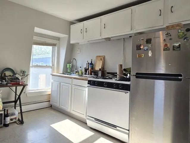 a kitchen with white cabinets and white appliances