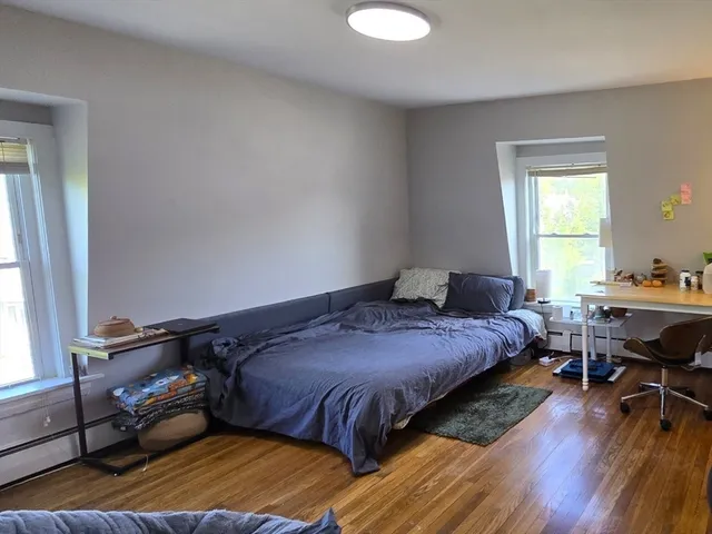 a bedroom with a bed and wooden floor