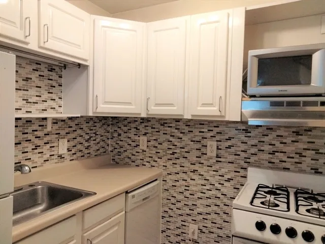 a kitchen with a sink a stove and microwave