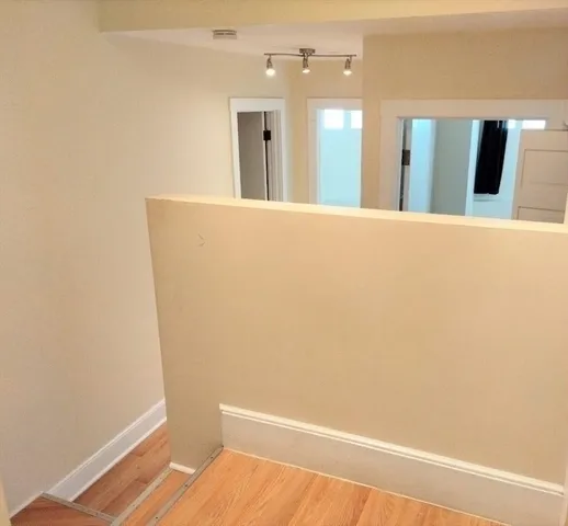 a view of a hallway with wooden floor