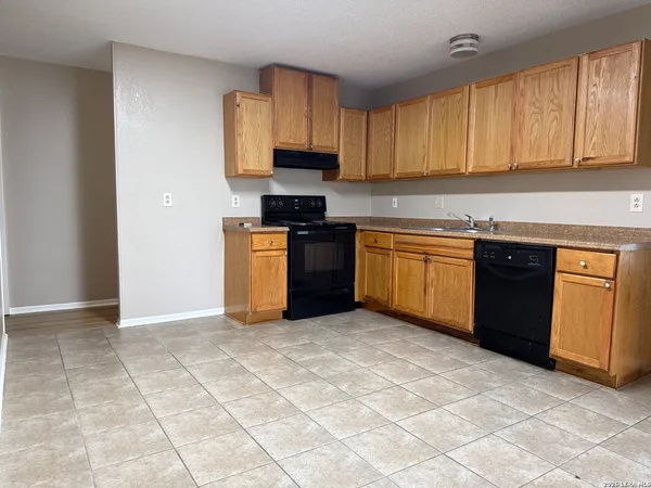 a kitchen with stainless steel appliances granite countertop a stove top oven a sink a counter space and cabinets
