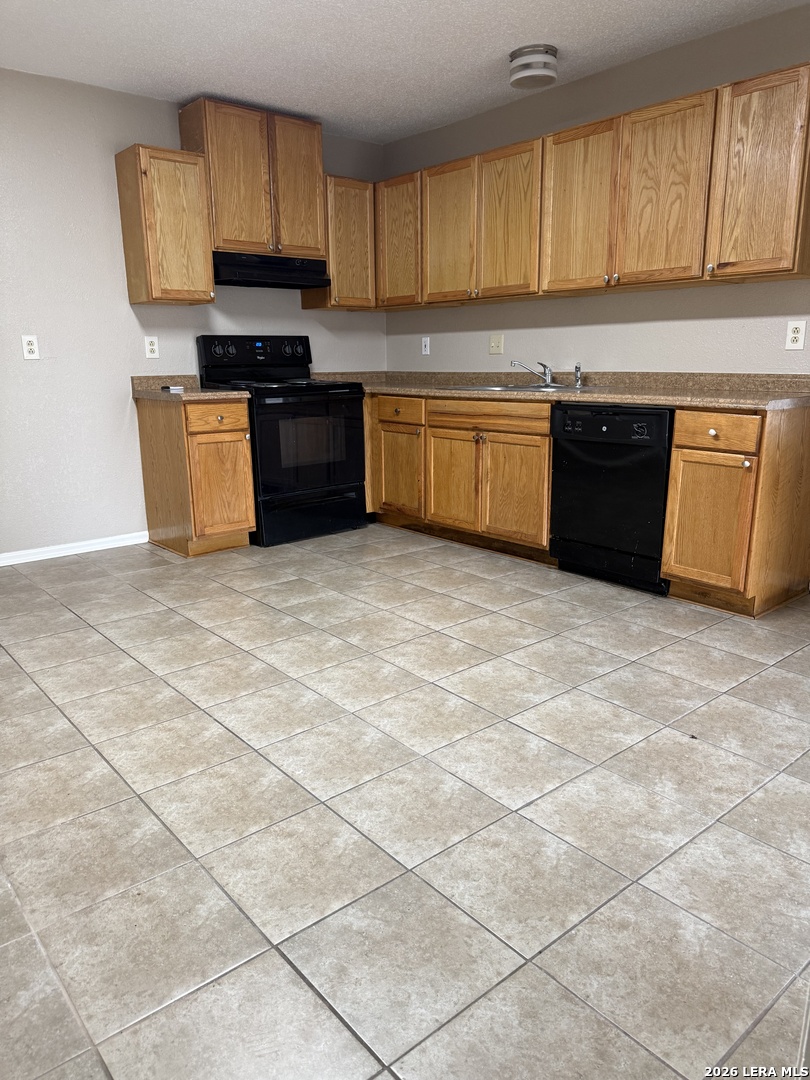 6626 Spring Garden Street San Antonio, TX 78249 - Photo 4 of 10 a kitchen with stainless steel appliances granite countertop a stove a sink and a microwave