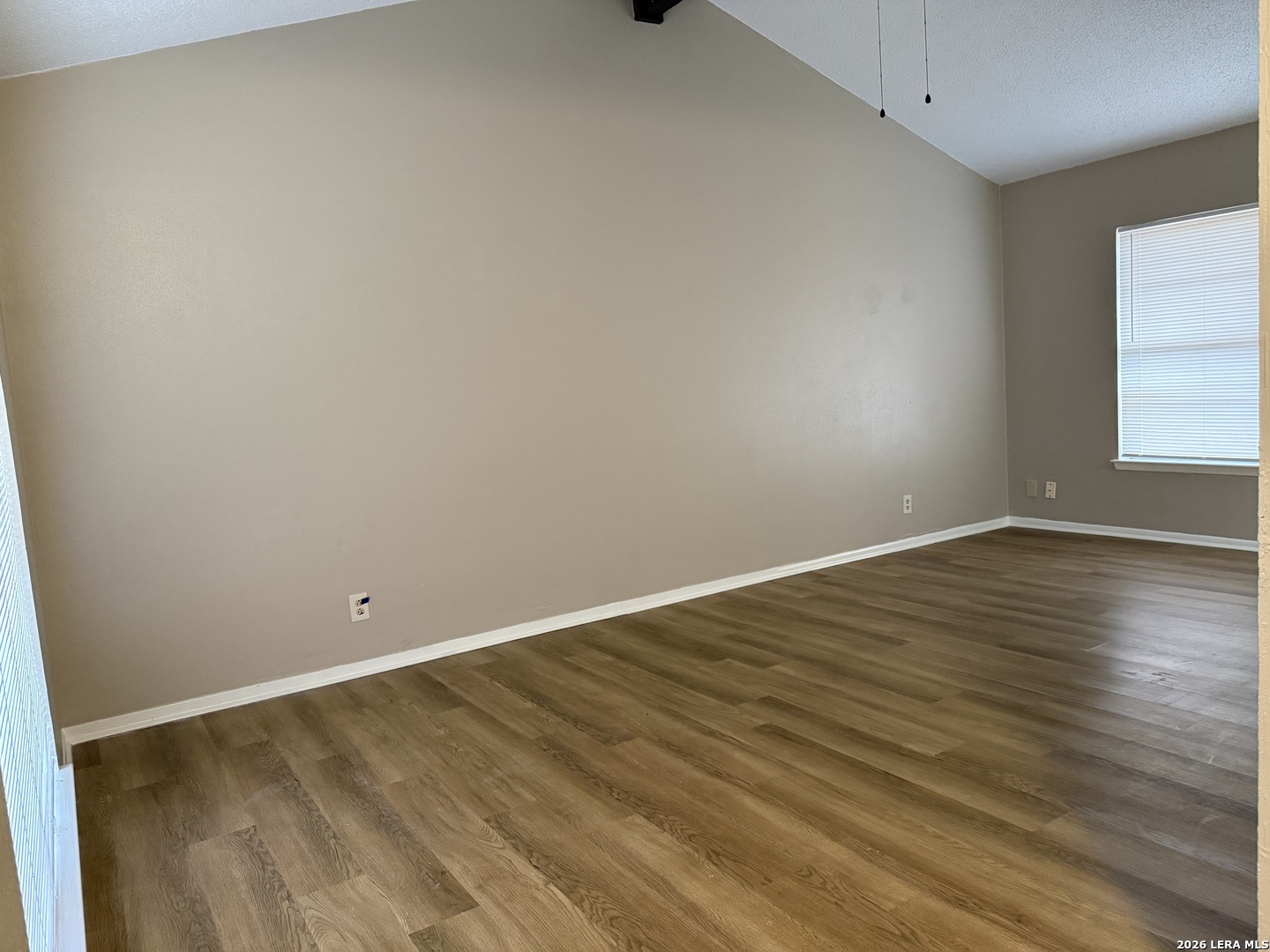 6626 Spring Garden Street San Antonio, TX 78249 - Photo 6 of 10 a view of an empty room with wooden floor and a window
