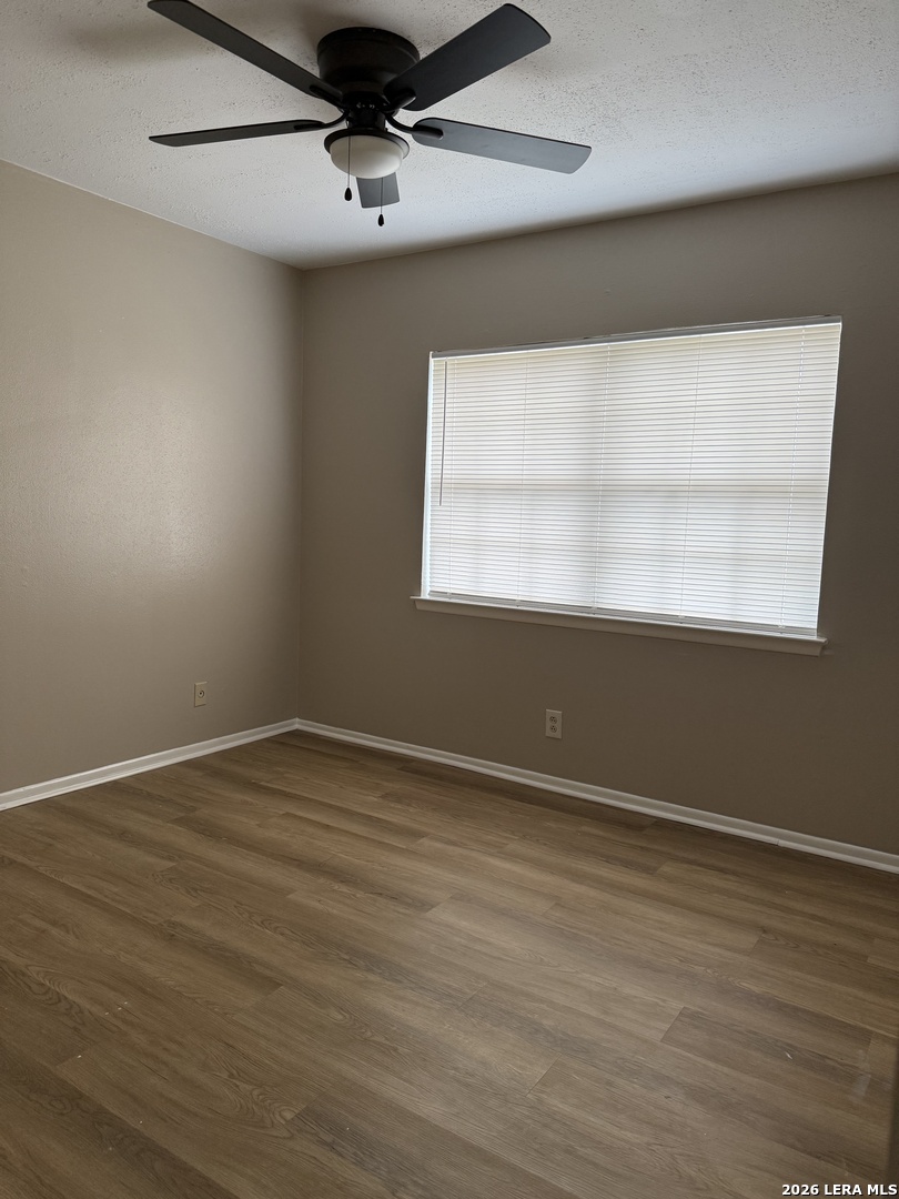 6626 Spring Garden Street San Antonio, TX 78249 - Photo 8 of 10 an empty room with wooden floor and windows