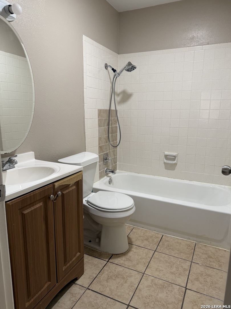 6626 Spring Garden Street San Antonio, TX 78249 - Photo 9 of 10 a bathroom with a granite countertop toilet a sink and a mirror