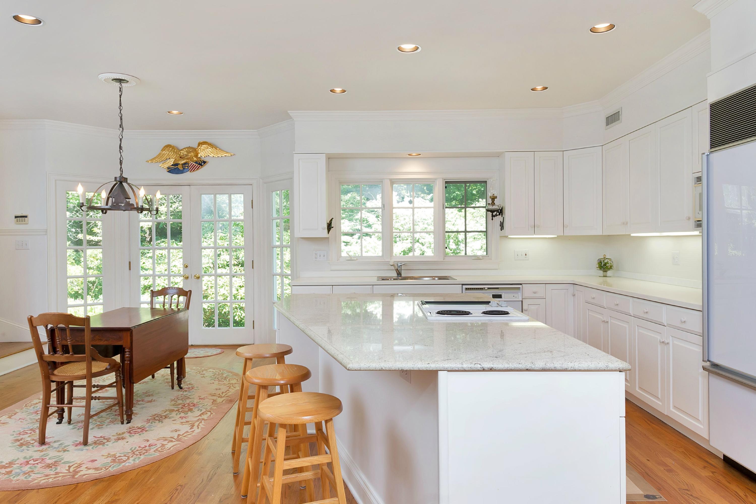 55 Rings End Road Darien, CT 06820 - Photo 10 of 29 a kitchen with a stove a refrigerator a sink a dining table and chairs with wooden floor