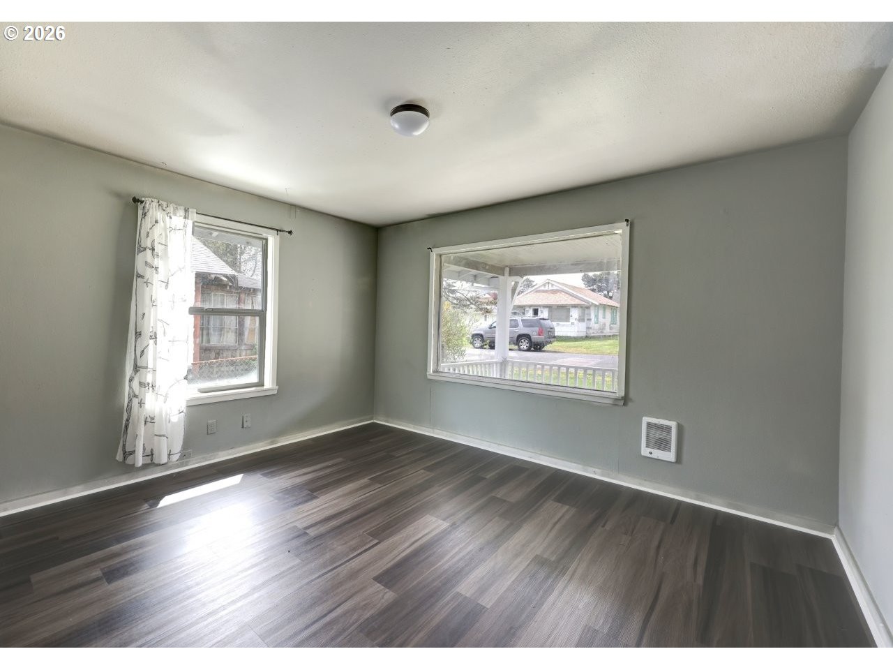 308 1st Street Garibaldi, OR 97118 - Photo 11 of 48 an empty room with wooden floor and windows