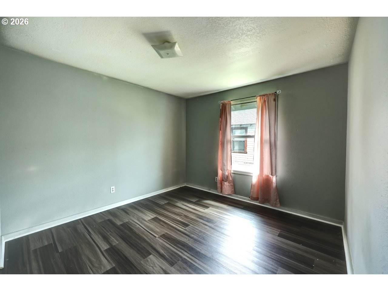 308 1st Street Garibaldi, OR 97118 - Photo 16 of 48 a view of an empty room with wooden floor and a window