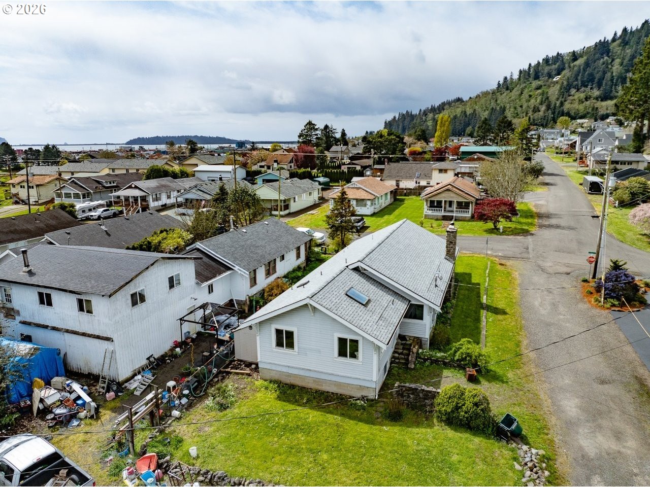 308 1st Street Garibaldi, OR 97118 - Photo 24 of 48 an aerial view of a house with a swimming pool a yard and mountain view in back