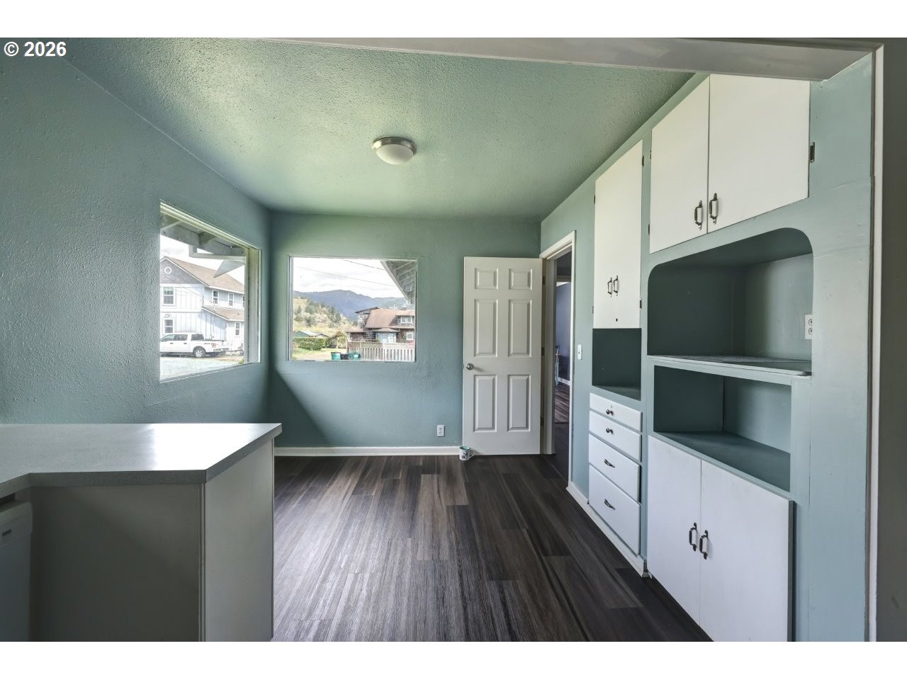 308 1st Street Garibaldi, OR 97118 - Photo 40 of 48 a living room with stainless steel appliances kitchen island granite countertop a refrigerator a stove a microwave oven with white cabinets and wooden floor