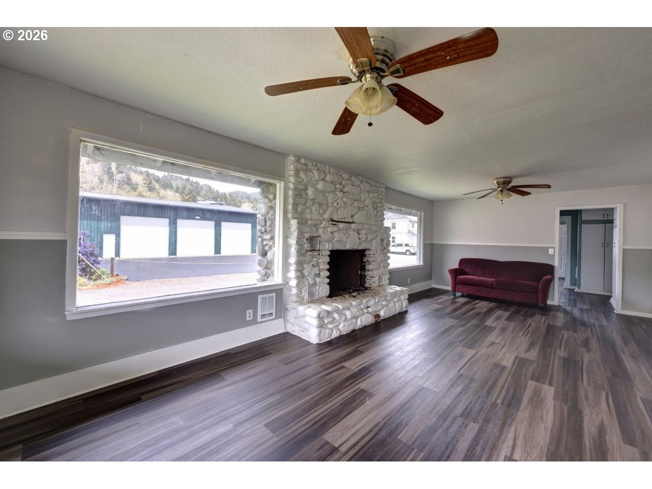 308 1st Street Garibaldi, OR 97118 - Photo 41 of 48 a living room with wooden floors and a fireplace