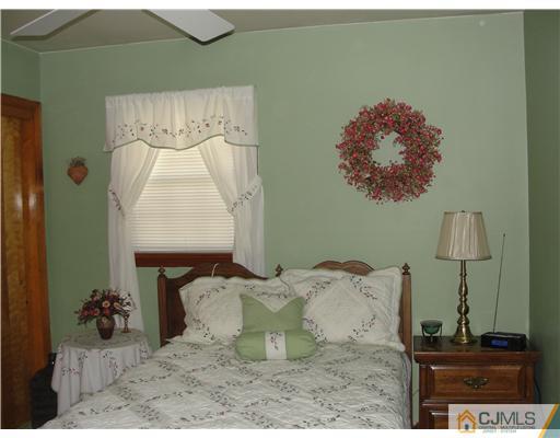 1107 New Dover Road Edison, NJ 08820 - Photo 7 of 10 a bed with a white comforter and pillows