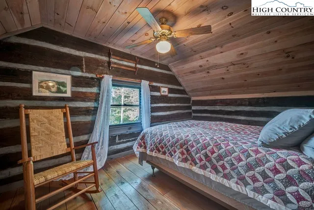 a bedroom with a bed and a flat tv screen on the dresser