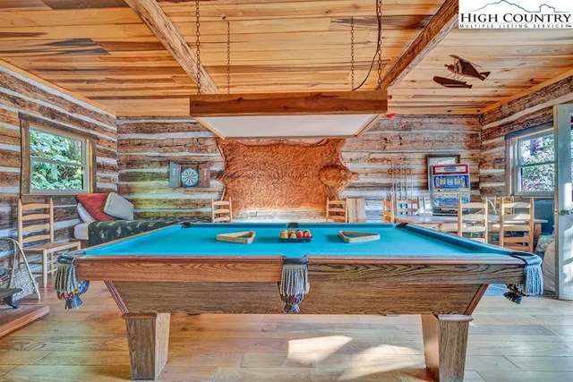 a room with pool table and windows