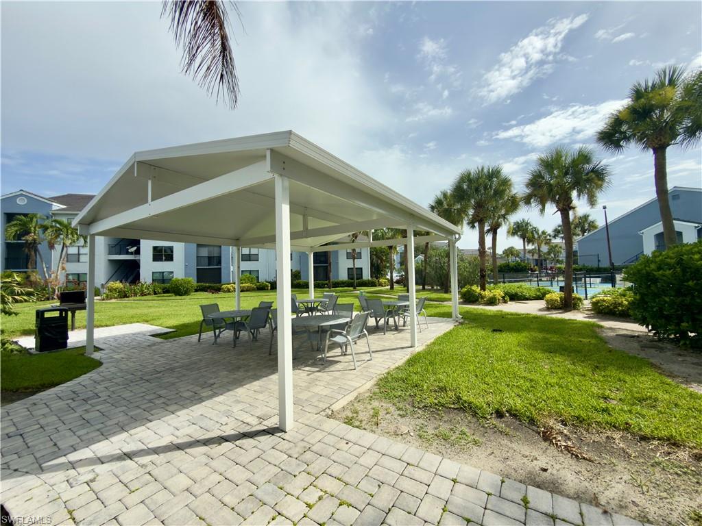13615 Eagle Ridge Drive, Unit 1614 Fort Myers, FL 33912 - Photo 19 of 34 Paved pool deck featuring a swimming pool, multiple lounge chairs, and perimeter fencing