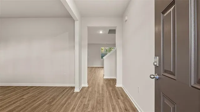 a view of a hallway with wooden floor and staircase