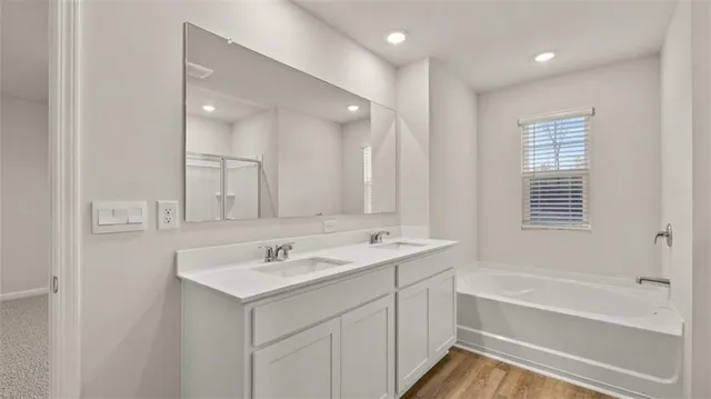 a bathroom with a sink a tub and a mirror