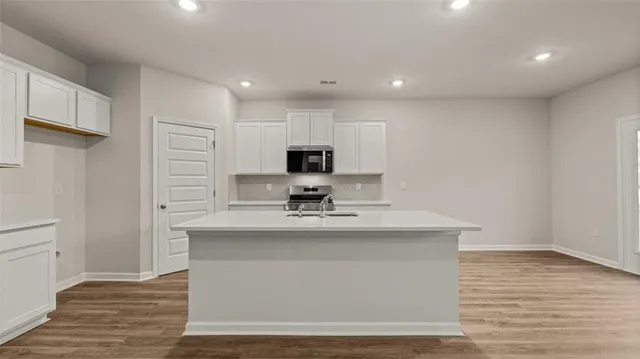 a view of kitchen with stainless steel appliances granite countertop refrigerator sink and cabinets
