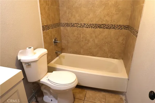 a white toilet sitting next to a bathroom sink and tub