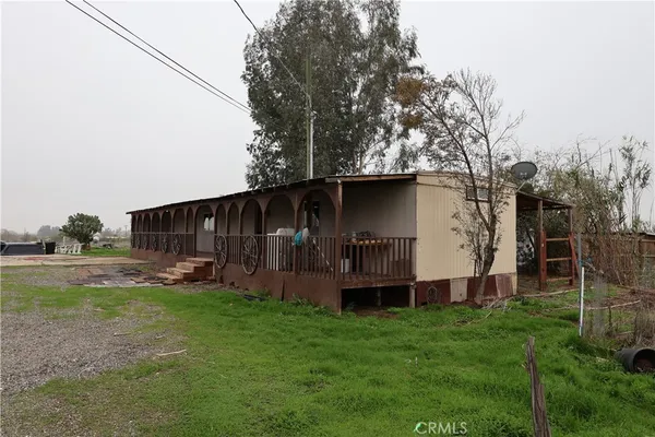 a view of a house with backyard and a tree
