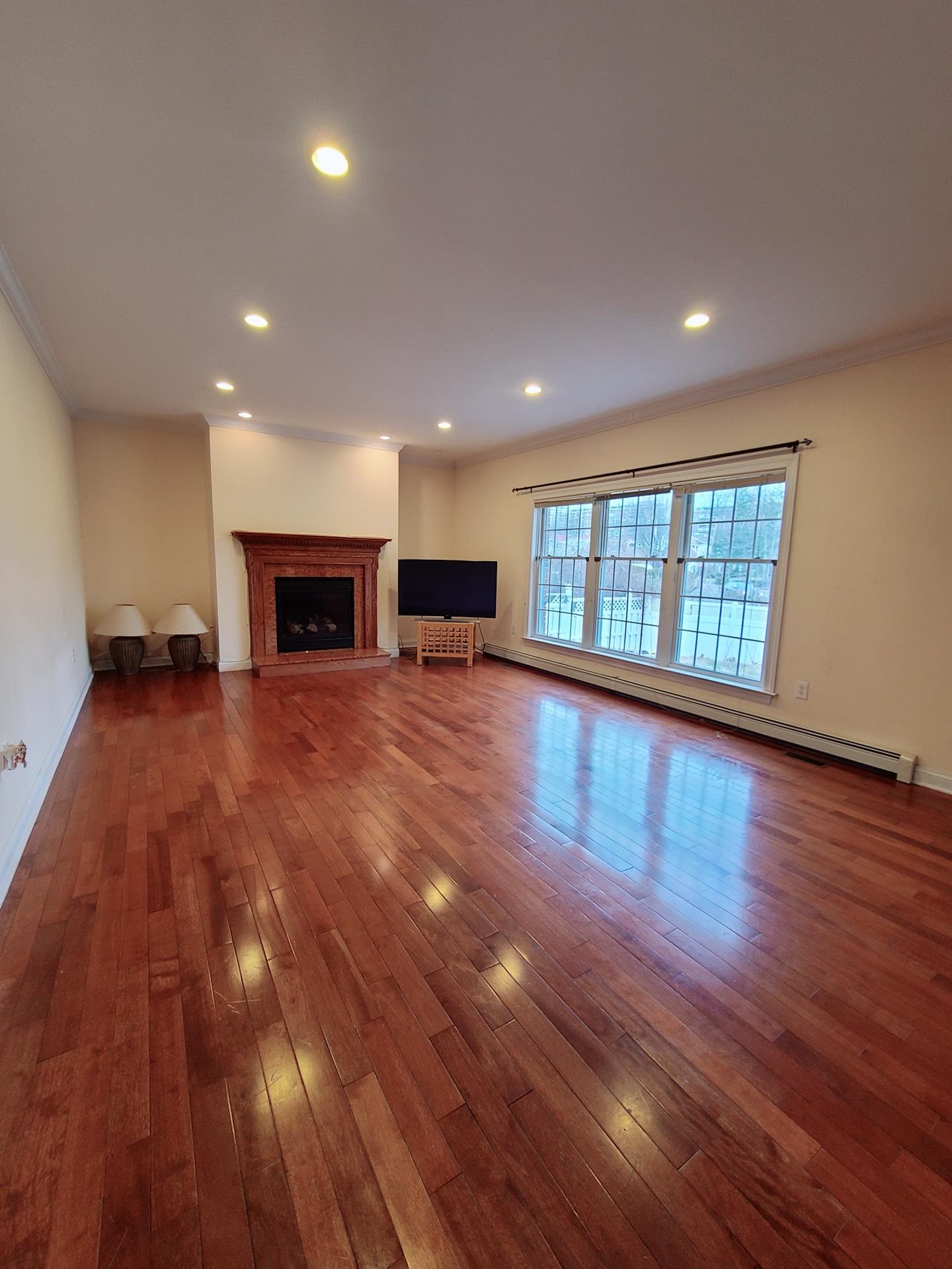 1170 Cumbermeade Road Fort Lee, NJ 07024 - Photo 2 of 7 an empty room with wooden floor and fireplace