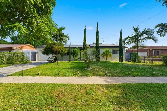 a front view of a house with a yard and palm trees