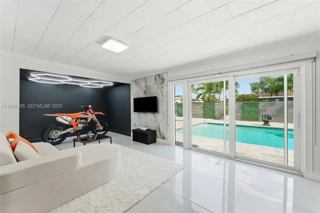 a living room with furniture a flat screen tv and a window
