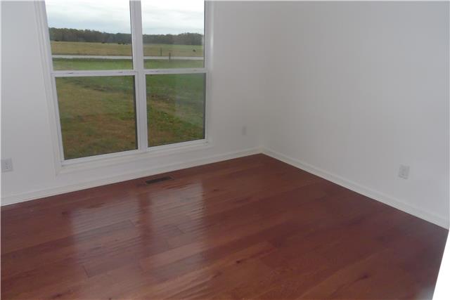 491 Rabbit Trail Road Leoma, TN 38468 - Photo 13 of 19 a view of an empty room with wooden floor and a window