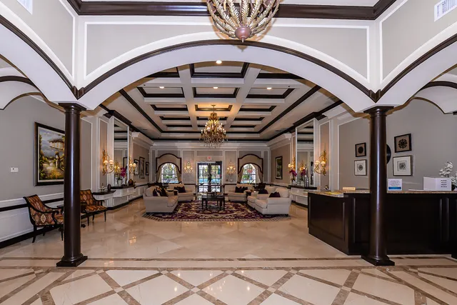 a view of a swimming pool with a yard and palm trees