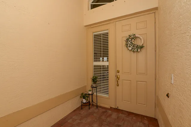 a living room with patio furniture and a floor to ceiling window