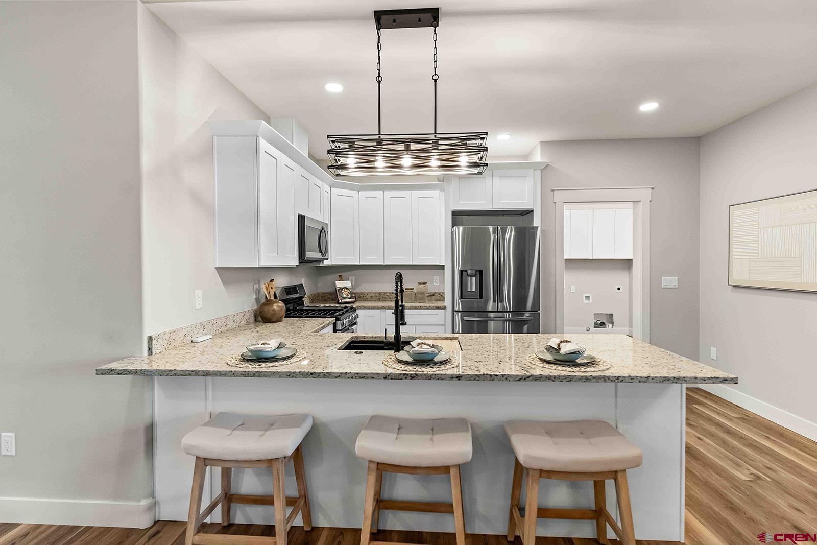 1533 Criterion Street Delta, CO 81416 - Photo 9 of 30 a kitchen with kitchen island granite countertop a sink and refrigerator