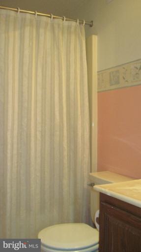 11316 Rawhide Road Lusby, MD 20657 - Photo 4 of 29 a bathroom with a shower curtain and sink