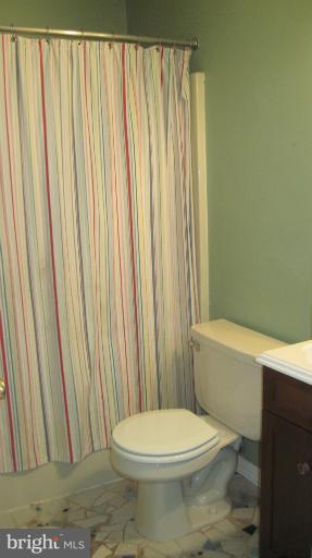 11316 Rawhide Road Lusby, MD 20657 - Photo 10 of 29 a bathroom with a toilet and a shower curtain
