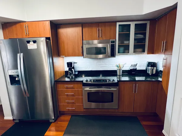 a kitchen with stainless steel appliances granite countertop a refrigerator stove top oven a sink and dishwasher