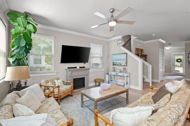 a living room with furniture kitchen view and a wooden floor